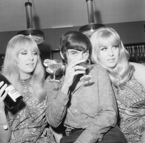 Manchester United footballer George Best celebrates the opening of his fashion boutique with a few glasses of champagne. 14th September 1967.